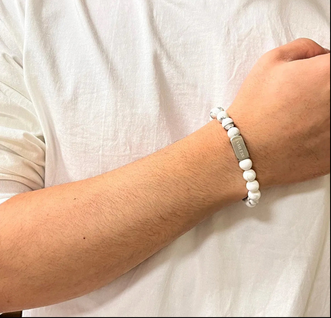 Pair of white marble beaded bracelets with gold and silver engraved metal accents